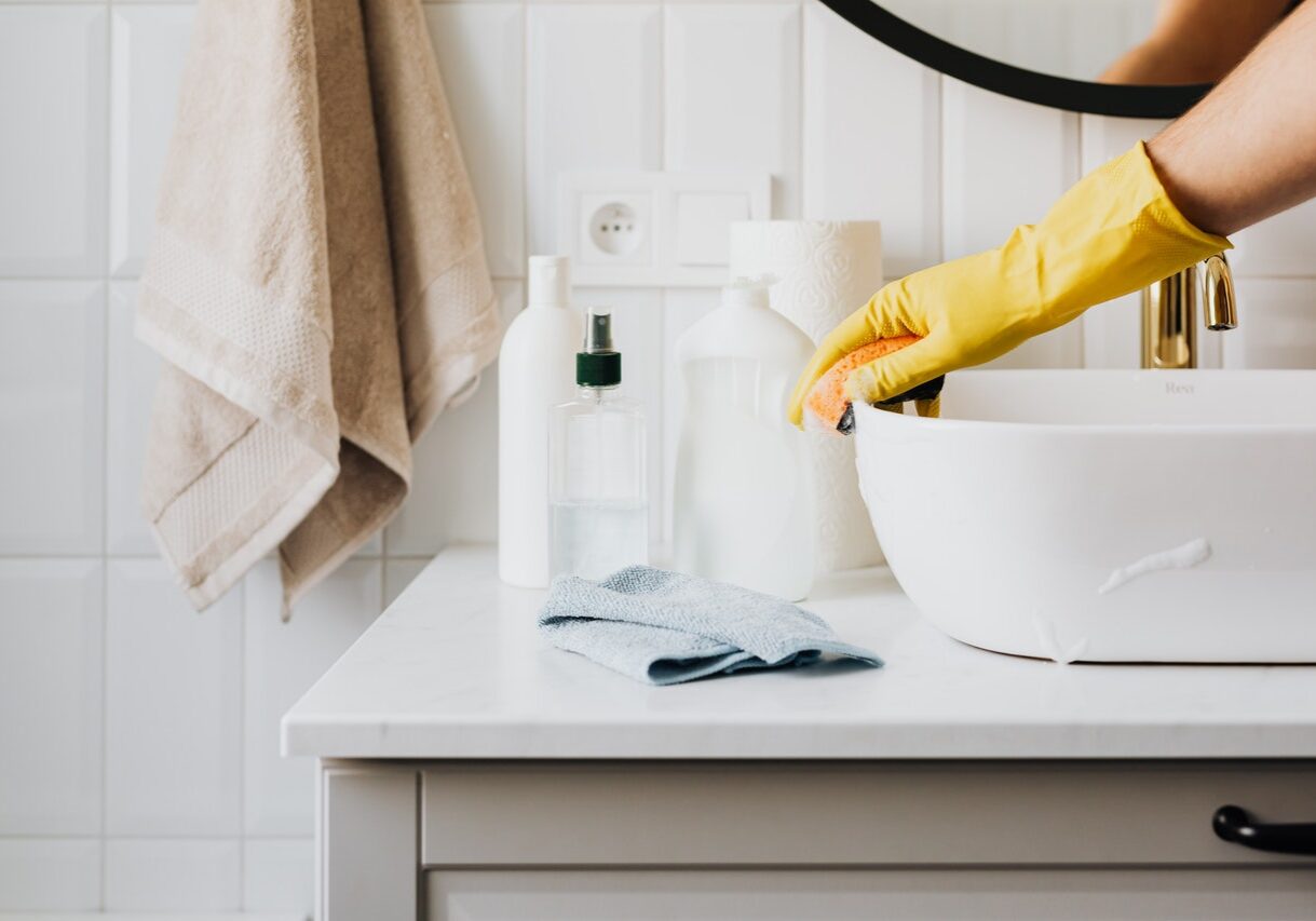 A person in yellow gloves is washing dishes.